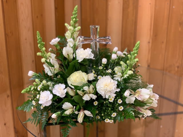White floral arrangement with a clear cross centerpiece