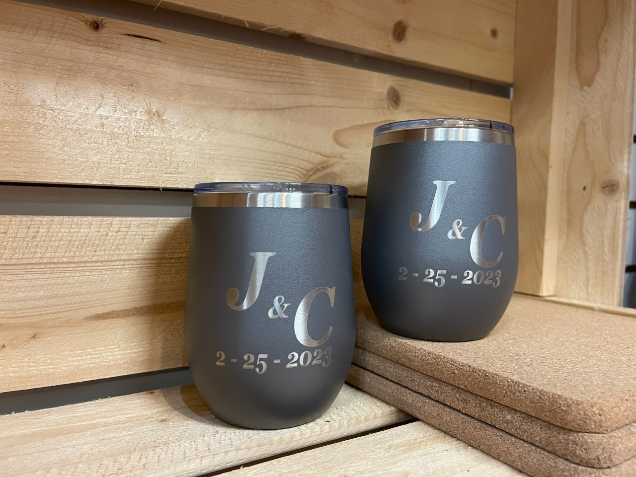 Two engraved black tumblers with initials and a date