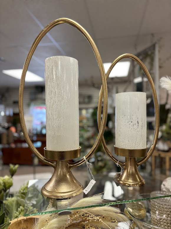 Two gold candle holders with white pillar candles