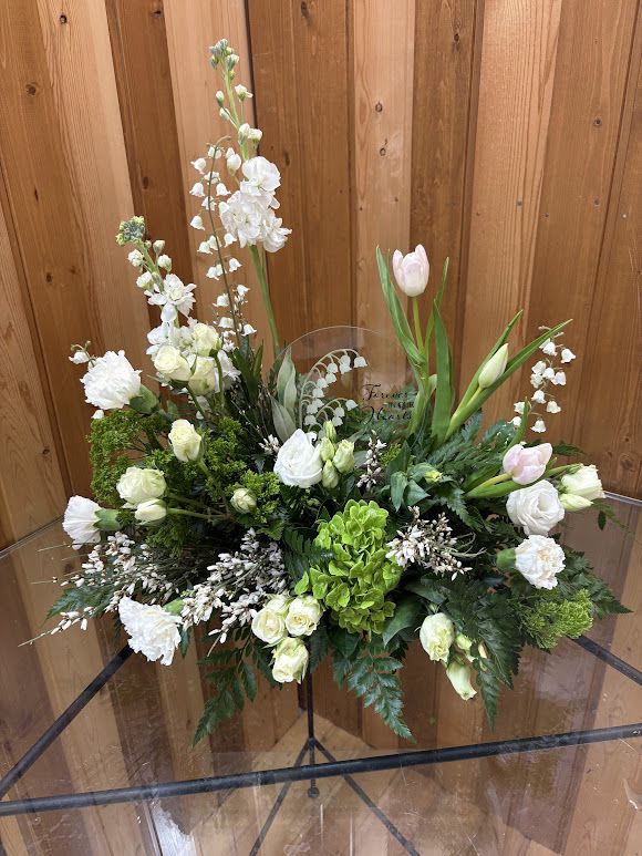White floral arrangement with tulips and roses in a clear vase