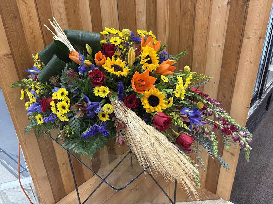 Mixed bouquet with sunflowers, roses, and lilies on a stand