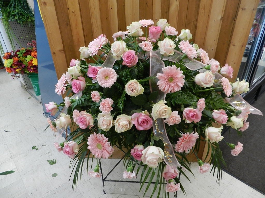 Large pink and white floral standing spray on a metal easel
