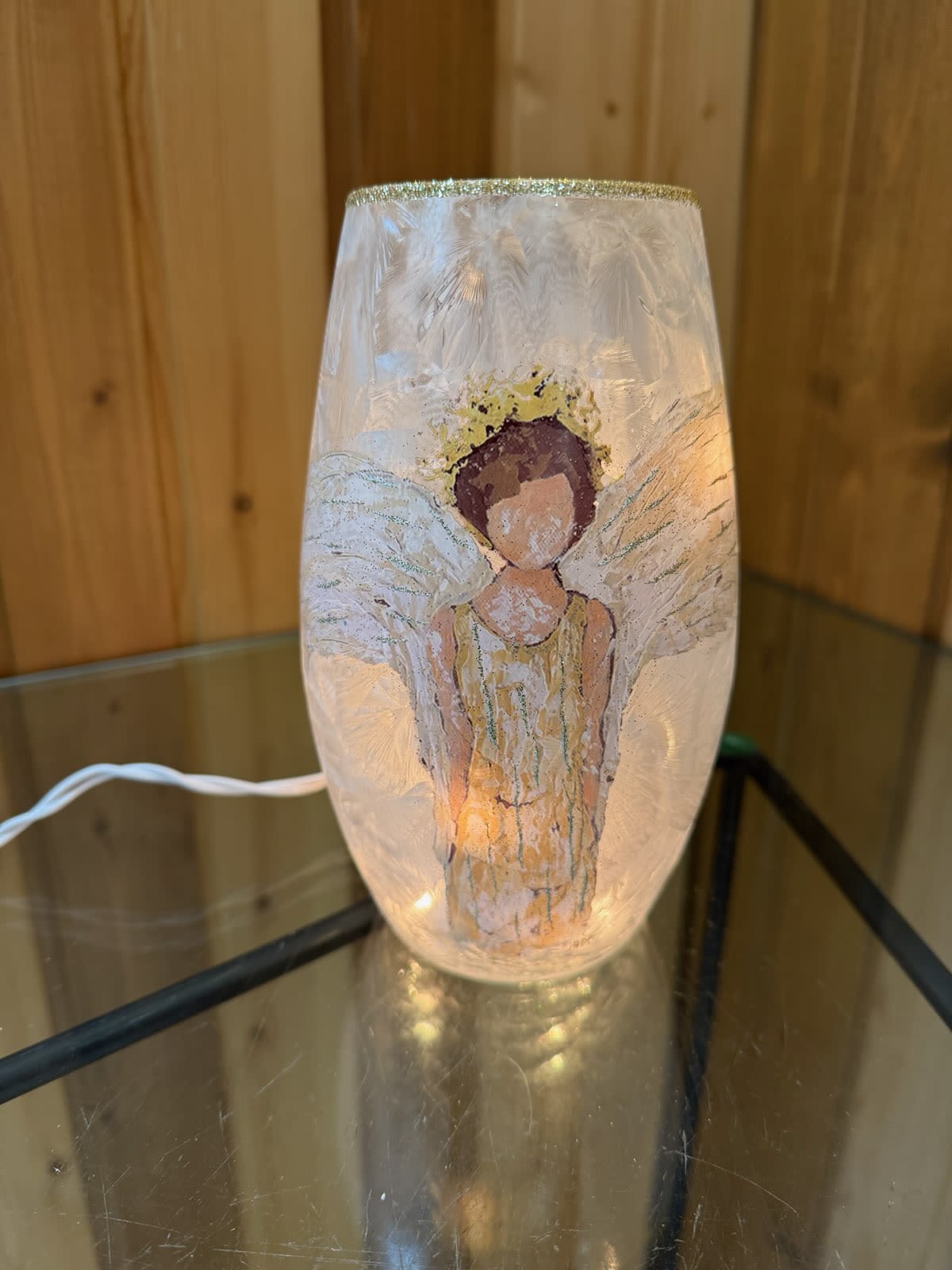 Decorative glass lamp with an angel figure inside