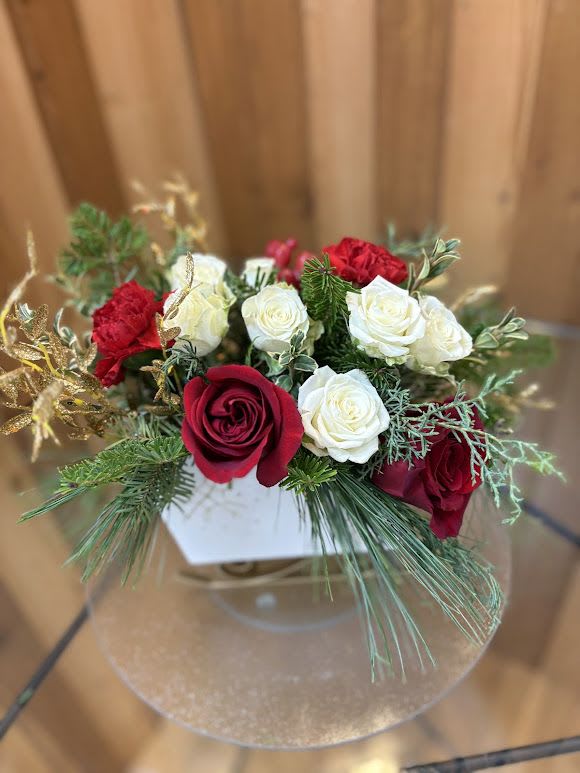 Red and white roses arranged in a clear round vase