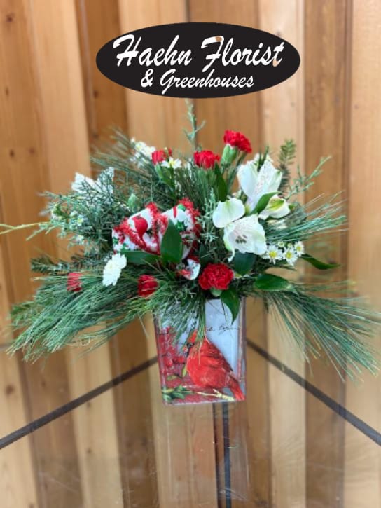 Red and white floral arrangement in a decorative container