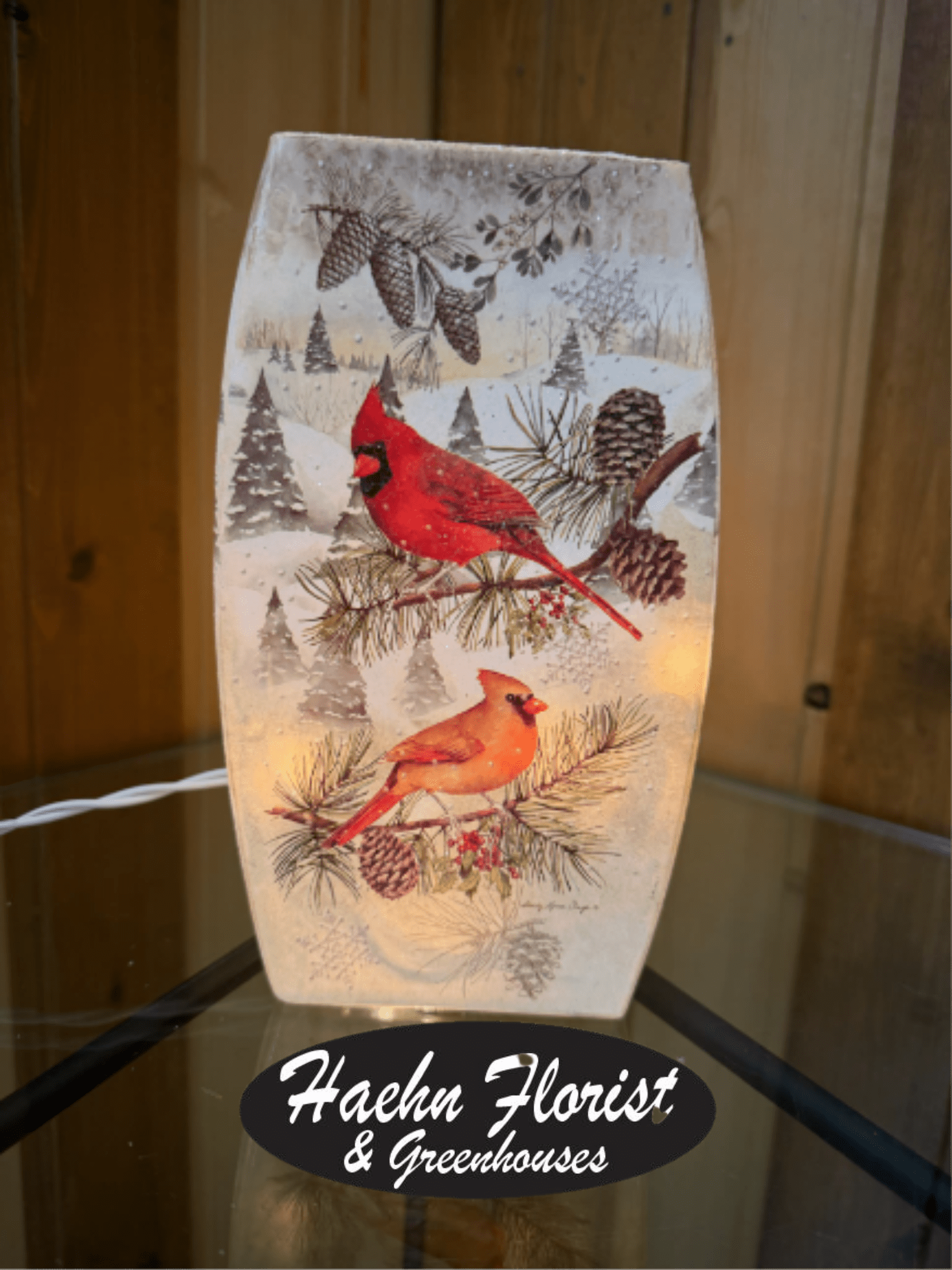 Decorative winter lantern with red cardinals and pinecones