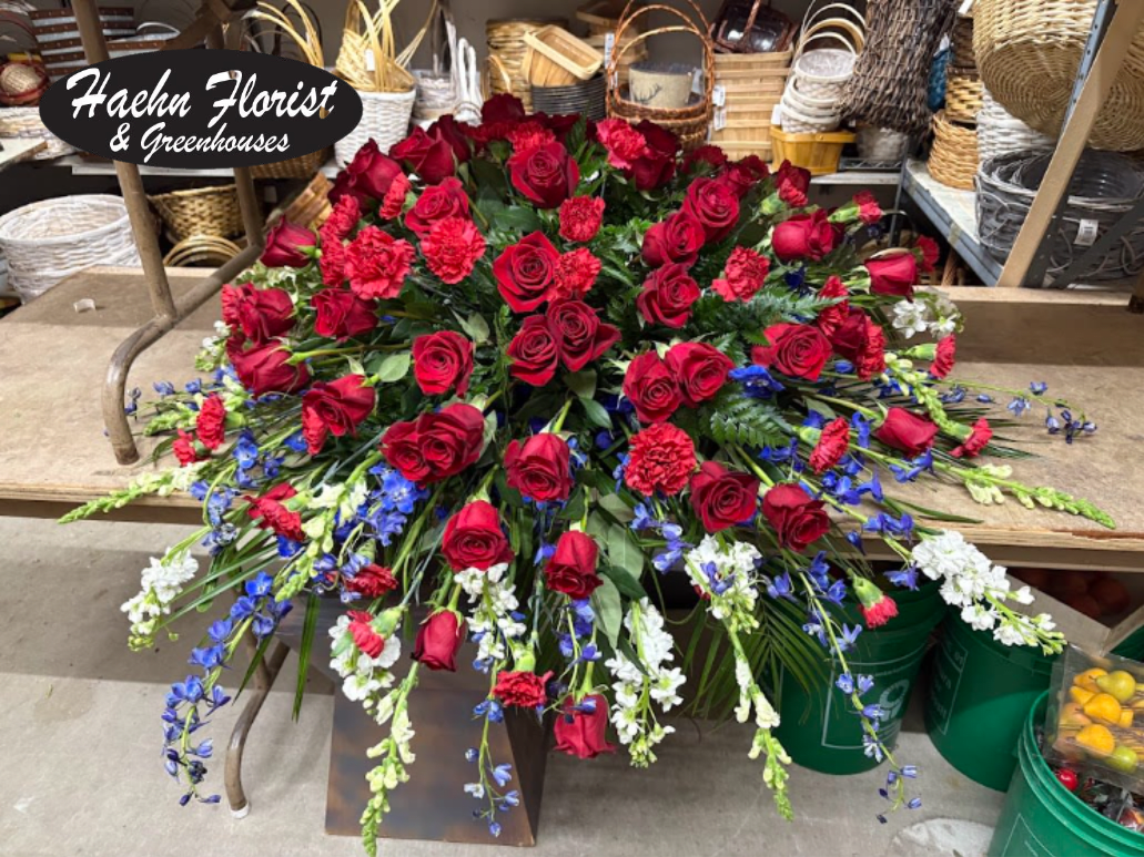 Large red rose arrangement with blue and white flowers in a store display