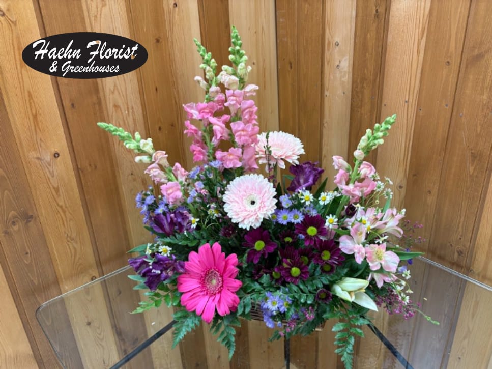 Country Blooms - Take a walk through a country meadow with this fresh flower basket! Pretty blooms of pink and purple nestle happily inside a natural gift basket as playful purple butterflies flutter overhead. Fresh flowers including snapdragons, alstroemeria, mini carnations are assembled in a natural basket with decorative butterflies. Orientation: One-Sided  SUBSTITUTION POLICY – Always deliver the freshest flowers! Please note the bouquet pictured reflects our original design.  If the exact flowers or container in this arrangement are not available, our local florists will create a beautiful bouquet with the freshest available flowers.