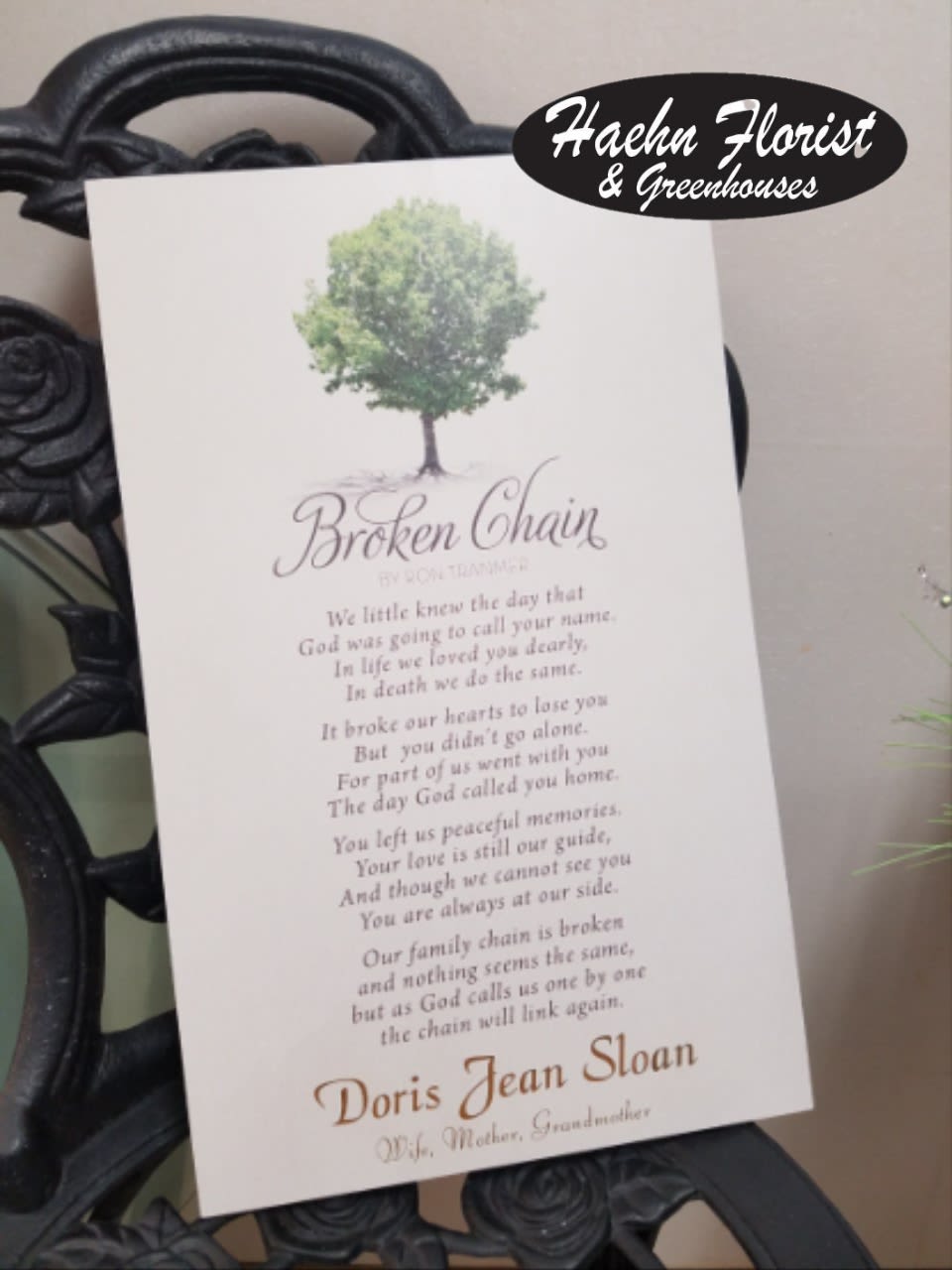 Memorial card with a tree graphic and poem on a black wrought-iron stand