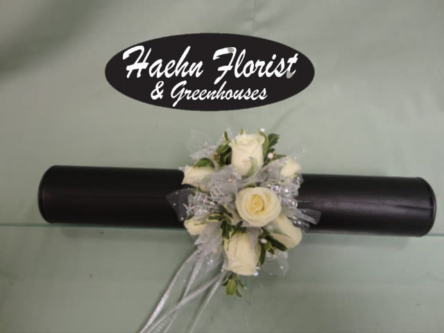 White rose corsage with silver ribbon on a black wristlet