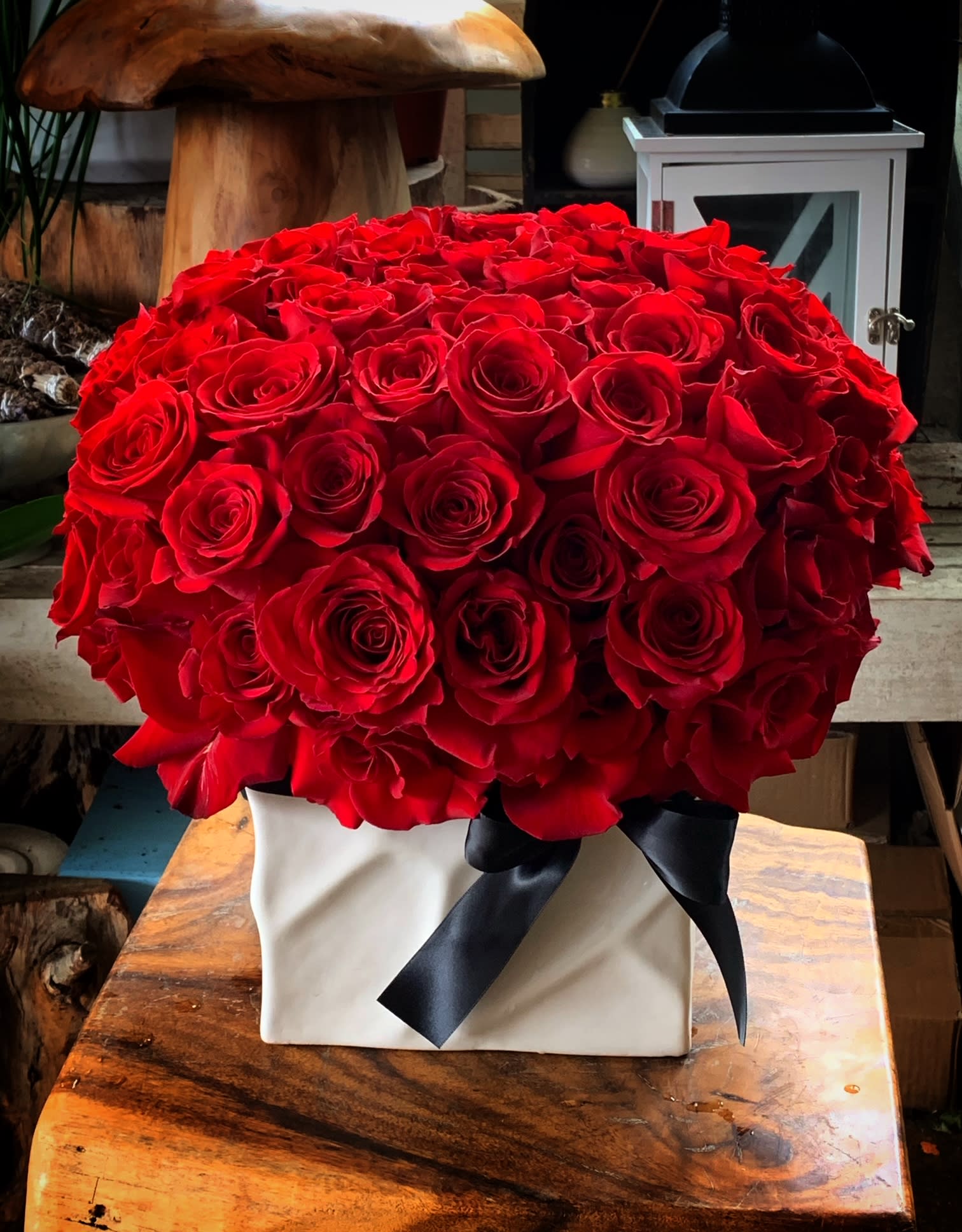 Large bouquet of red roses in a white box with a black ribbon