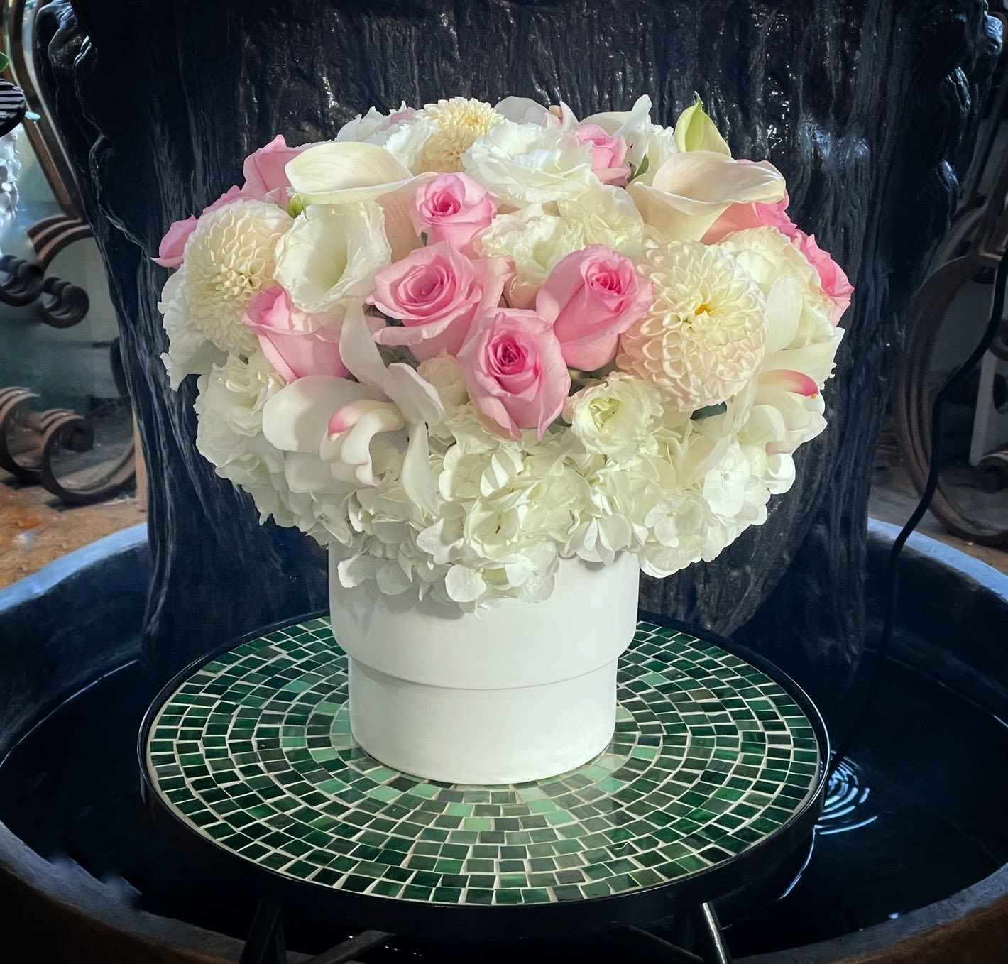 Pink and white floral arrangement in a white hatbox