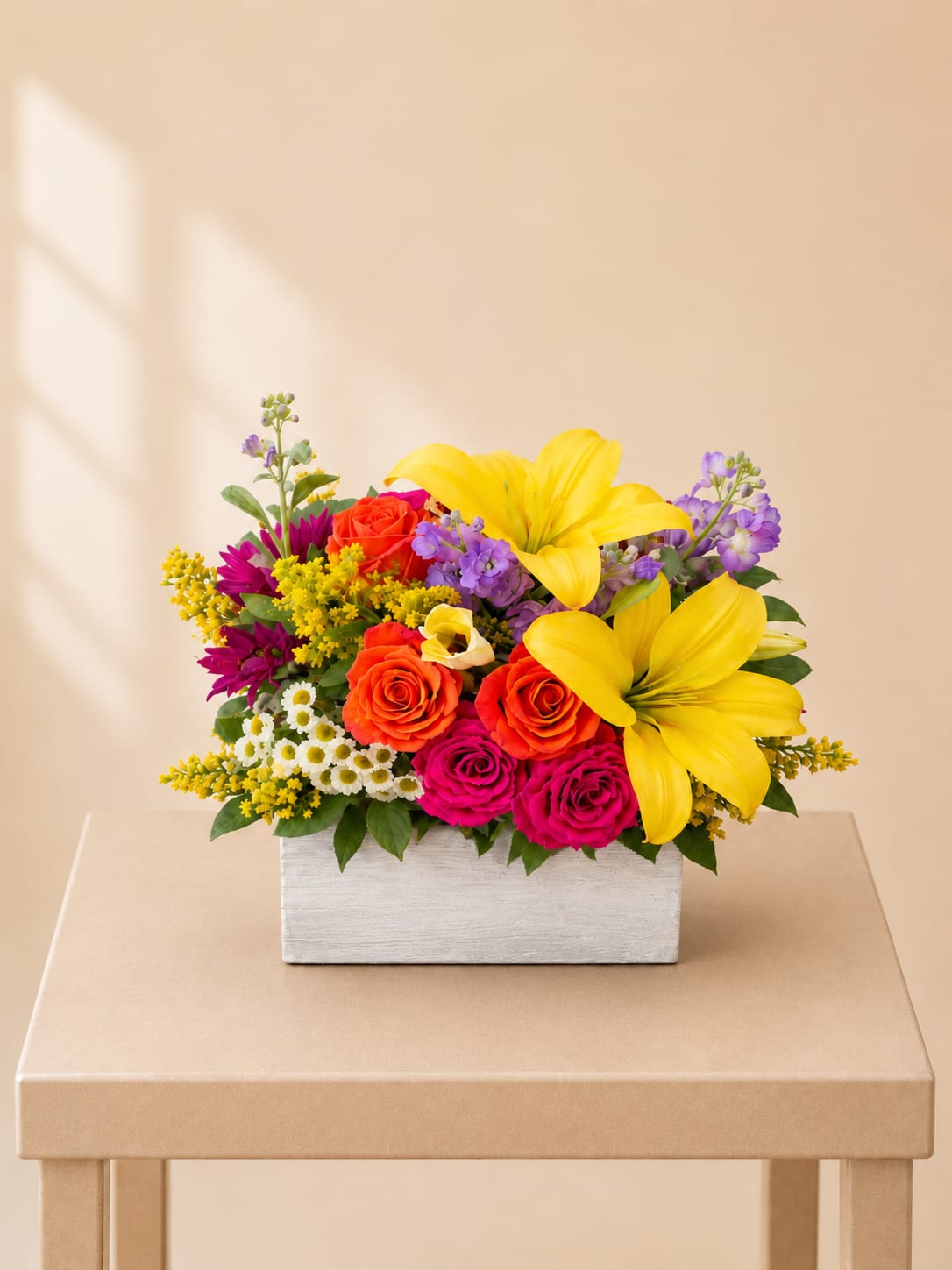 Bright mixed bouquet in a white rectangular box with yellow lilies and roses