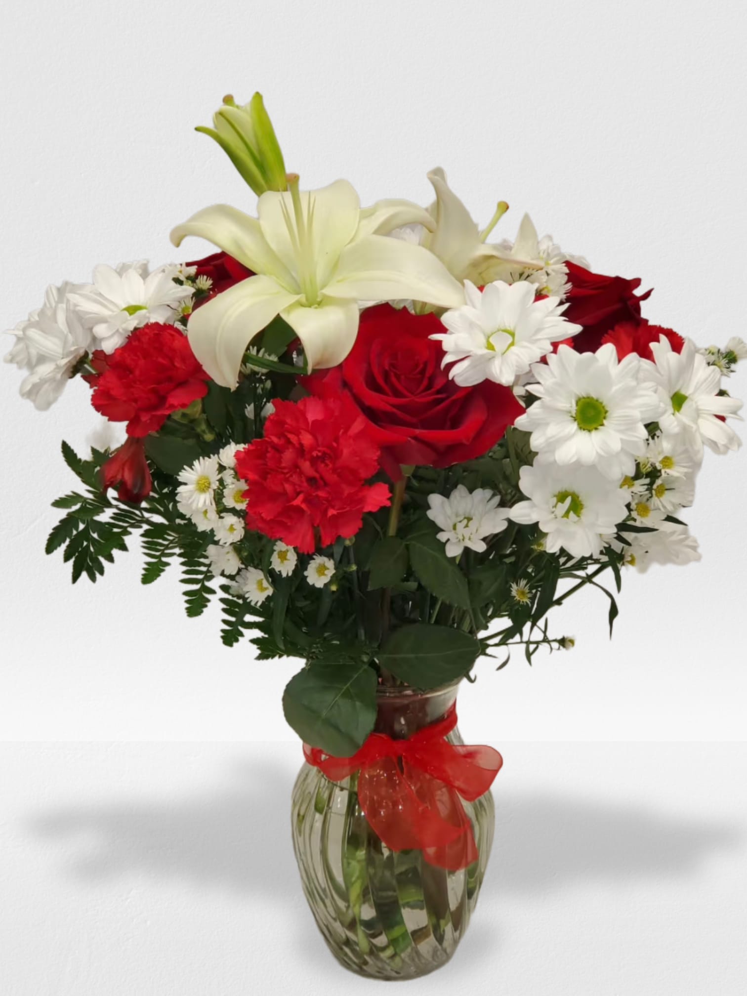 Boldly Bashful by Manny - This bouquet is a sweet way to show someone you care. Boldly Bashful is a great gift for Valentine's Day or Birthday.   Arrangement Details: Includes white chrystanthemum spray daisies, pink carnations, and red roses.  APPROXIMATE DIMENSIONS: 12" H X 10" W