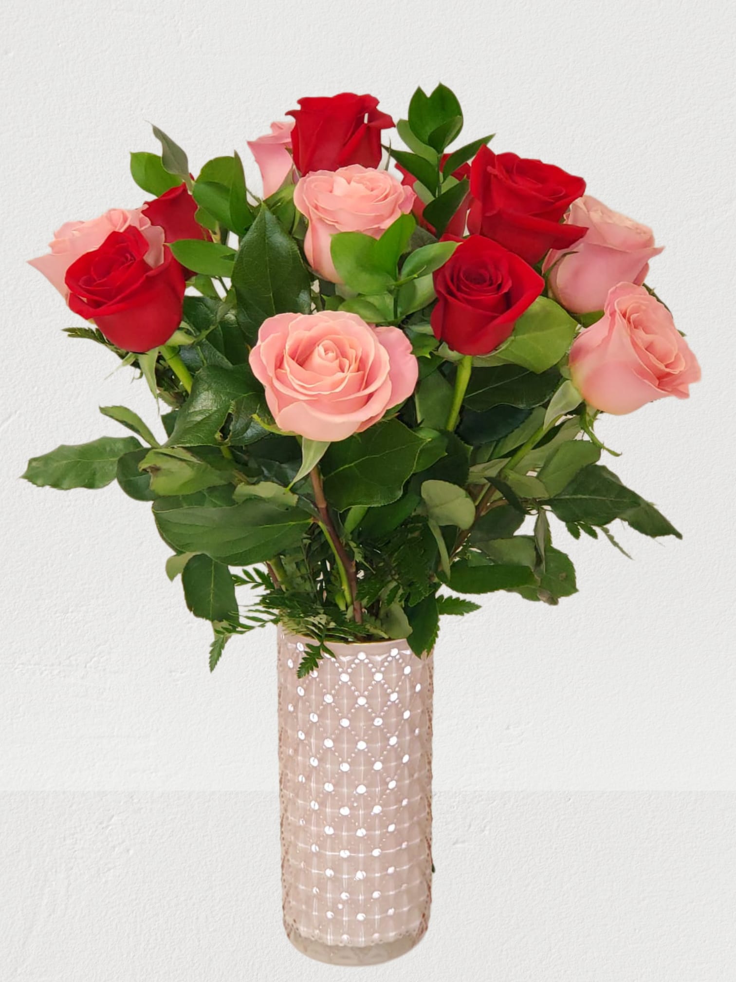 Bouquet of red and pink roses in a tall glass vase