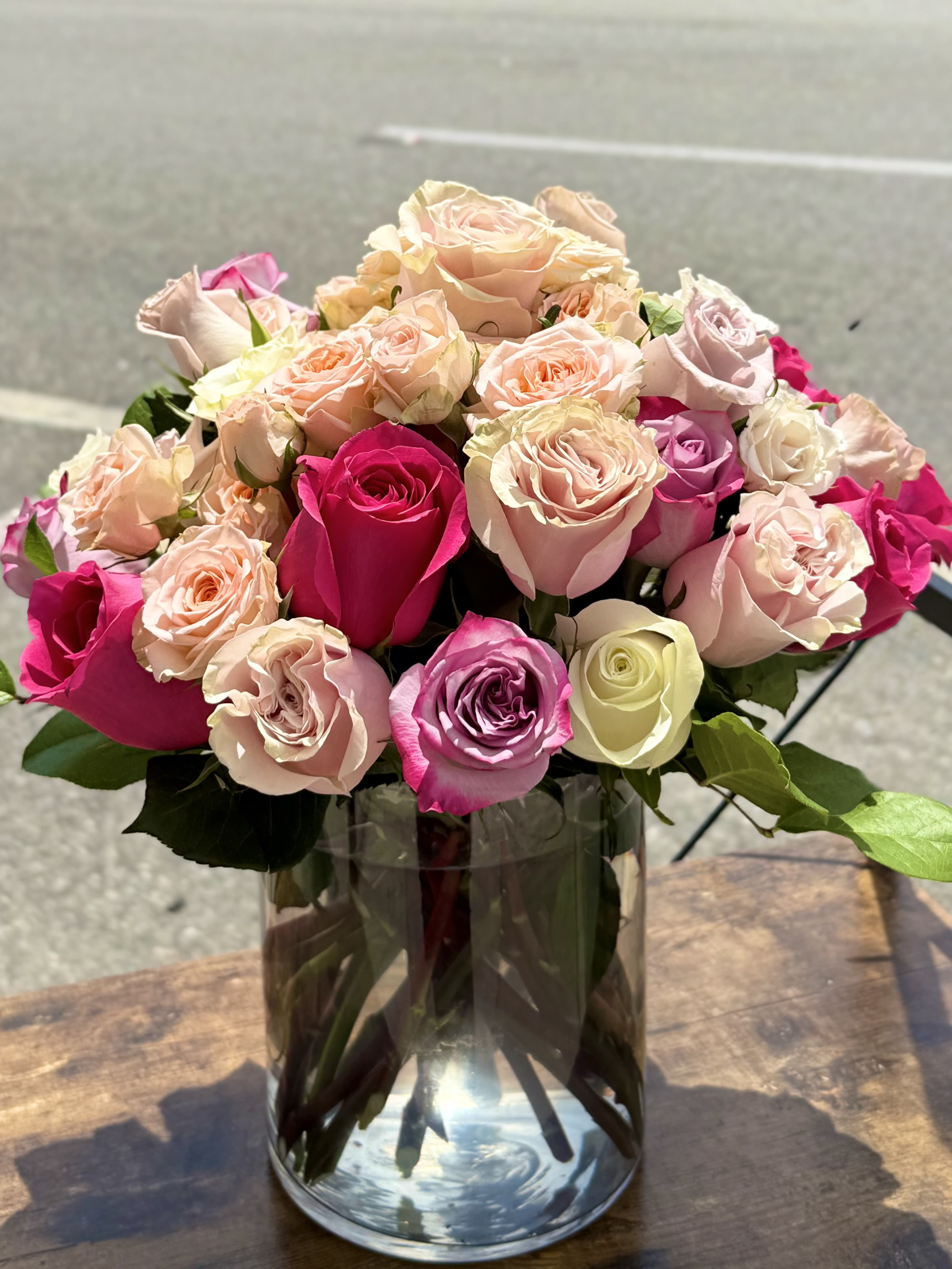 Bouquet of pink and peach roses in a clear glass vase