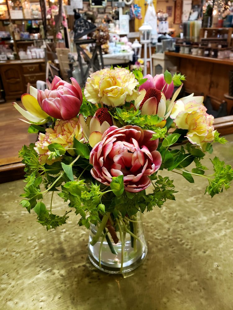 Mixed bouquet of pink and cream flowers in a clear glass vase
