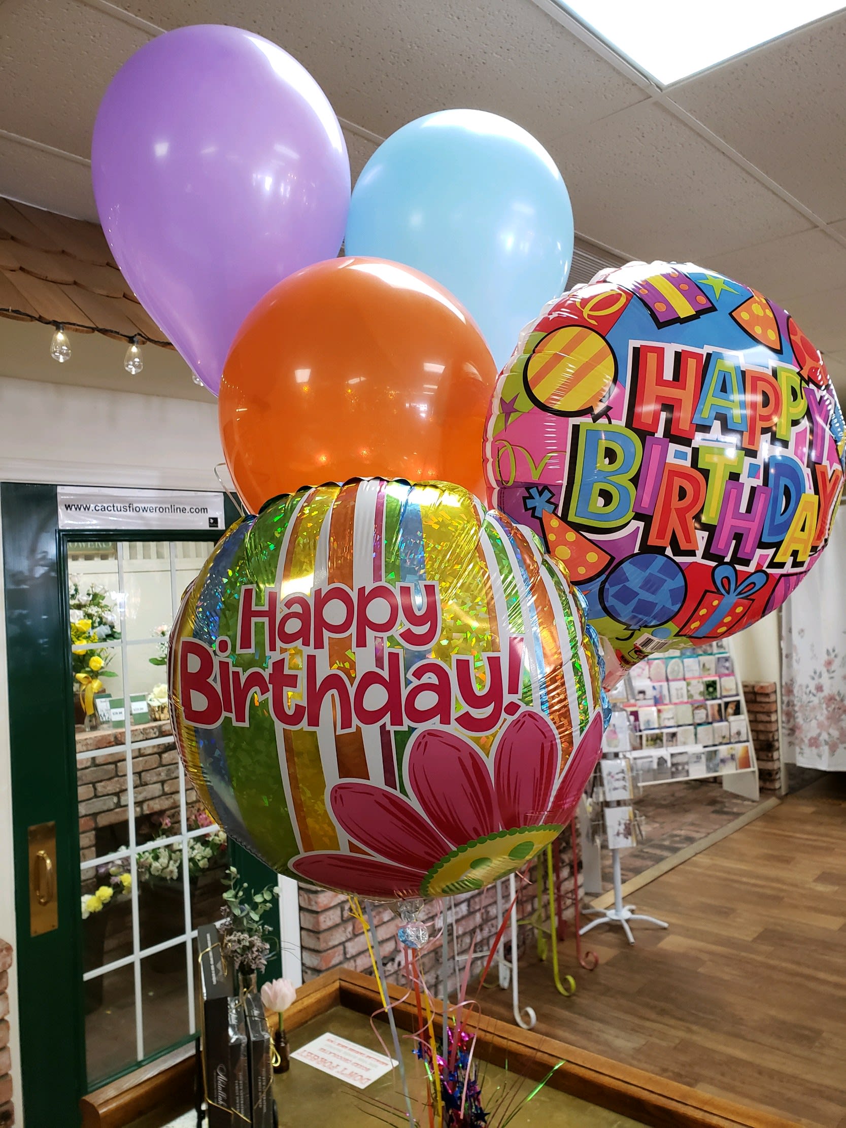 Birthday balloons in pastel colors and two printed Happy Birthday balloons