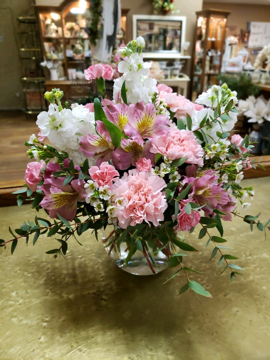 Pink and white floral arrangement in a clear glass vase