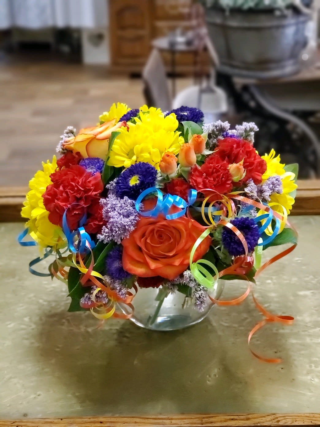 Birthday Bowl  - Festive arrangement with roses, carnations, asters, daisies and colorful curling ribbon 
