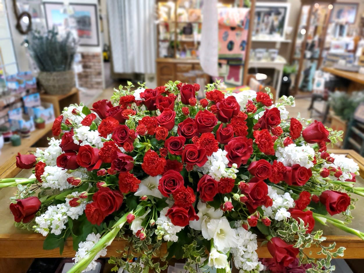 Large arrangement of red roses and white flowers on a table