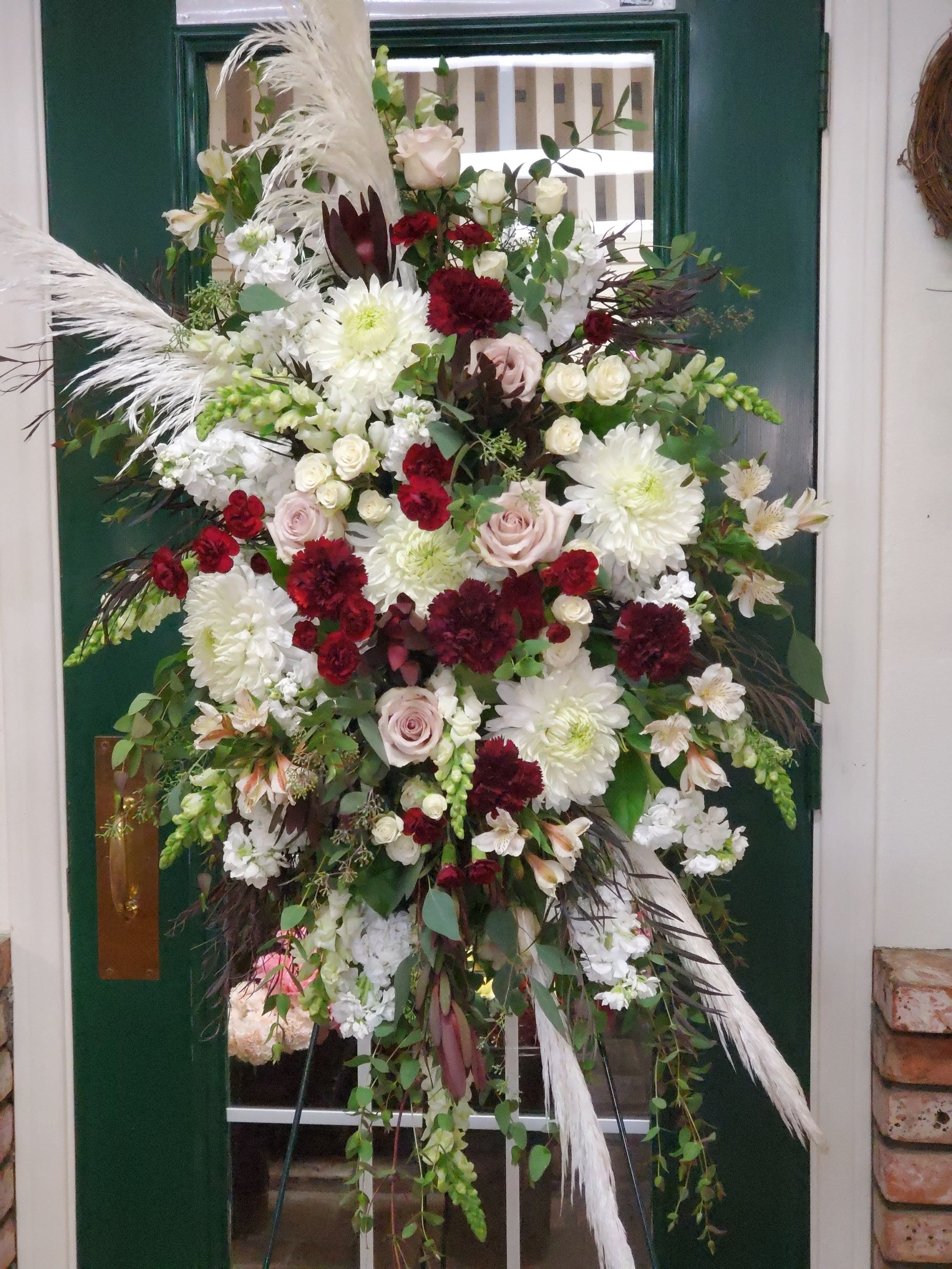 Large standing floral spray with white, blush, and burgundy blooms