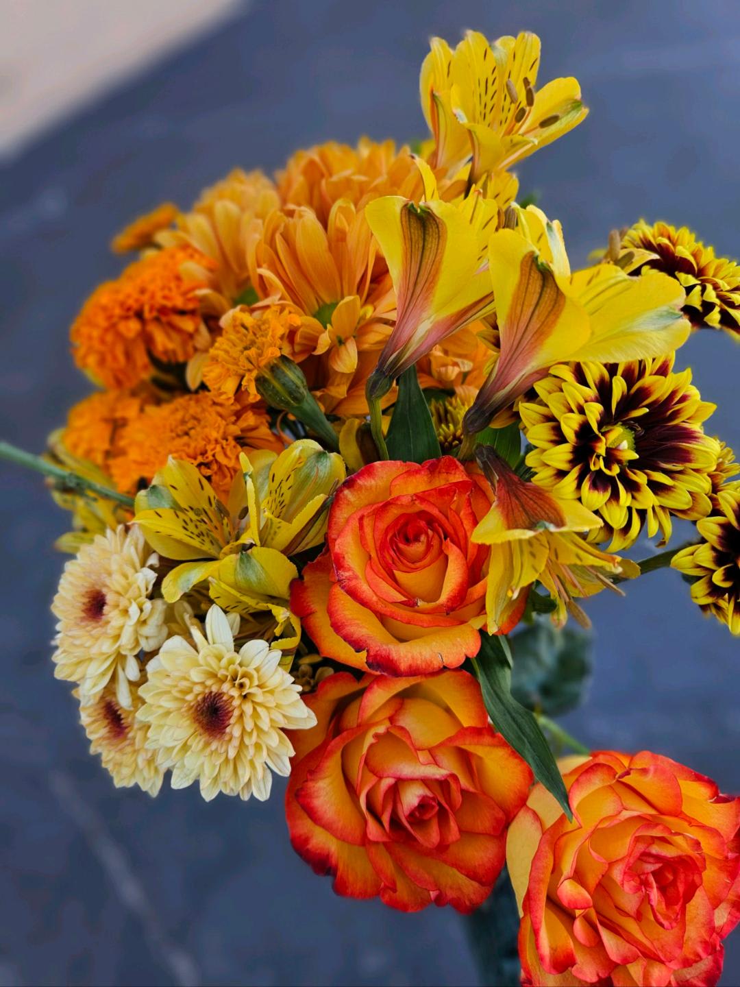 Bouquet of orange and yellow roses with mixed daisies and alstroemeria