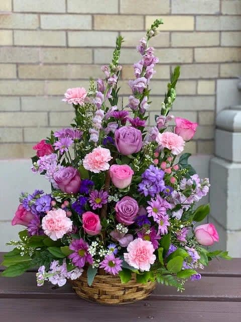 Basket arrangement of pink and purple flowers with tall spikes