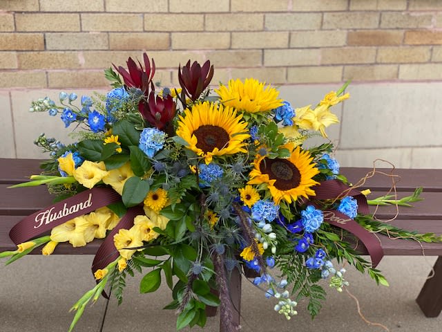 Bouquet with sunflowers, blue flowers, and yellow blooms tied with ribbons