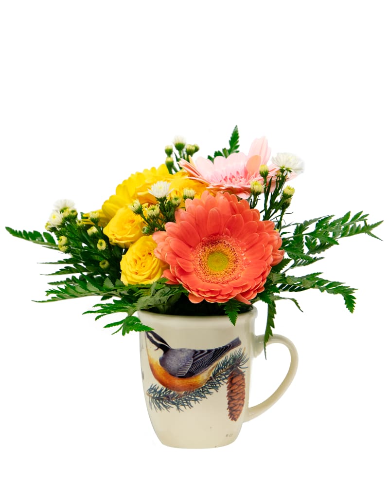 Mixed flowers arranged in a bird-printed mug