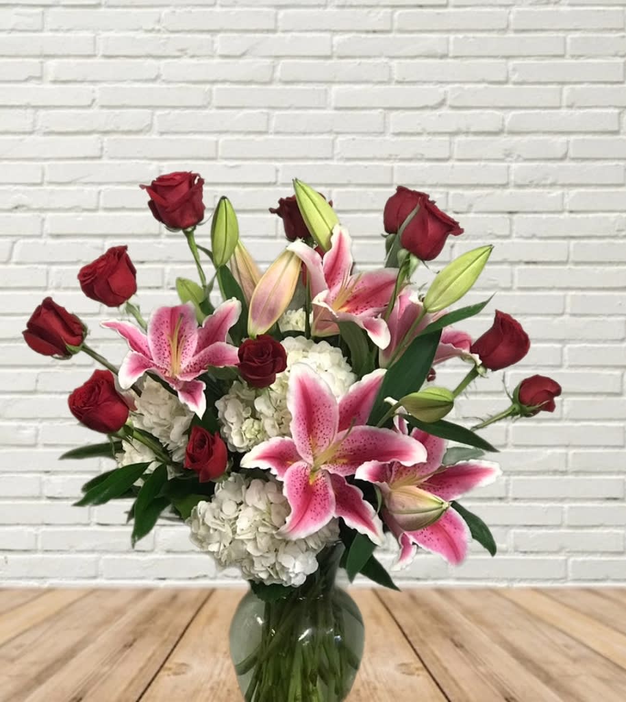 Bouquet of red roses and pink lilies in a glass vase