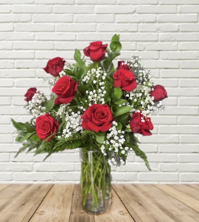 Red roses and white baby's breath in a clear glass vase