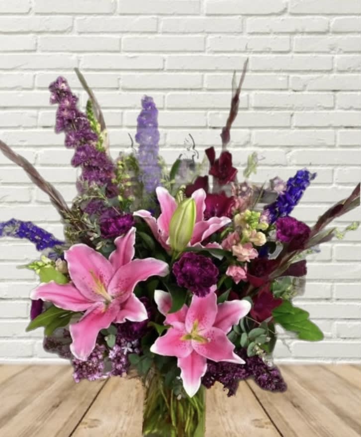 Bouquet of pink lilies and purple flowers in a hand-tied arrangement