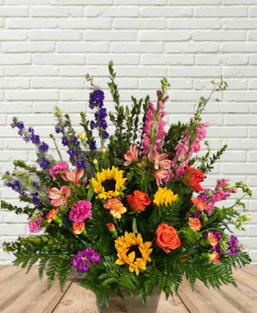 Large mixed flower arrangement with sunflowers, roses, and pink and purple blooms