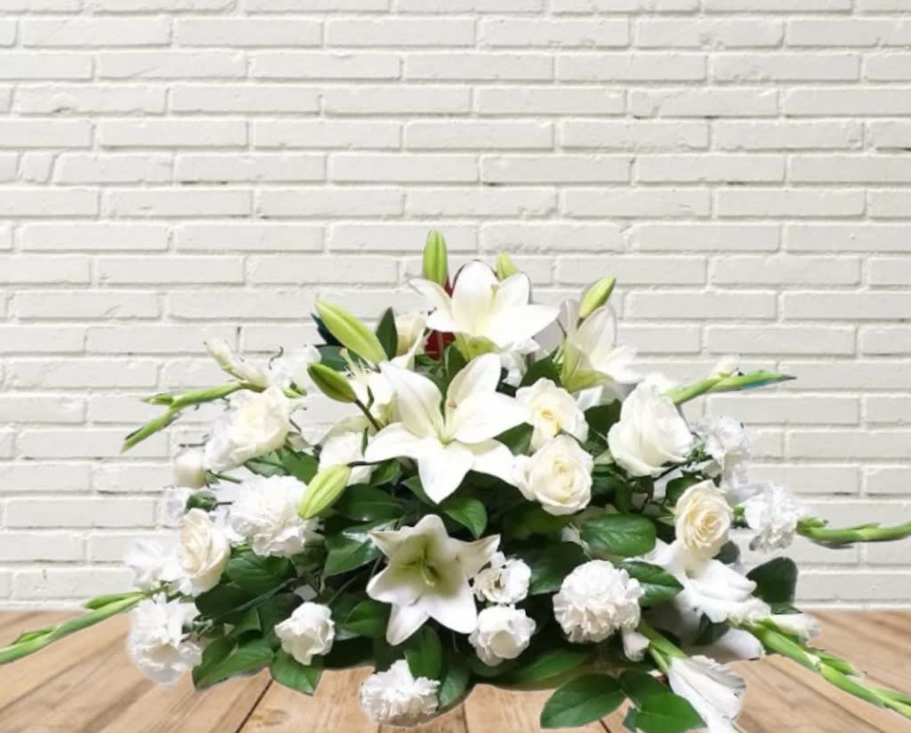 White lily and rose arrangement with green buds on a low base
