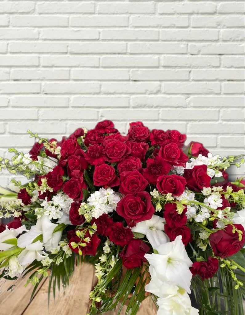 Large red and white floral arrangement with roses and lilies