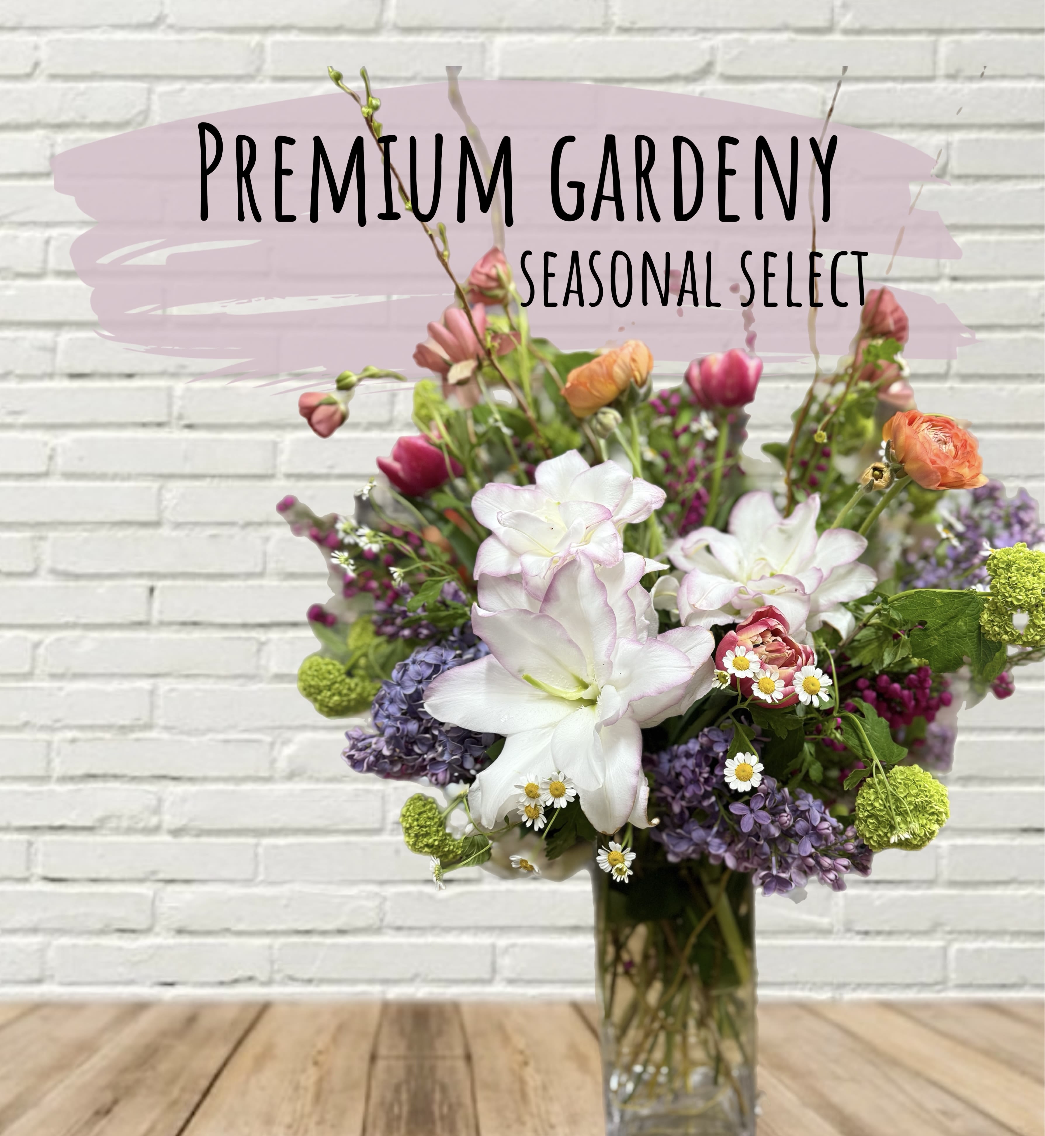 Mixed bouquet of white, pink, purple, and orange flowers in a glass vase