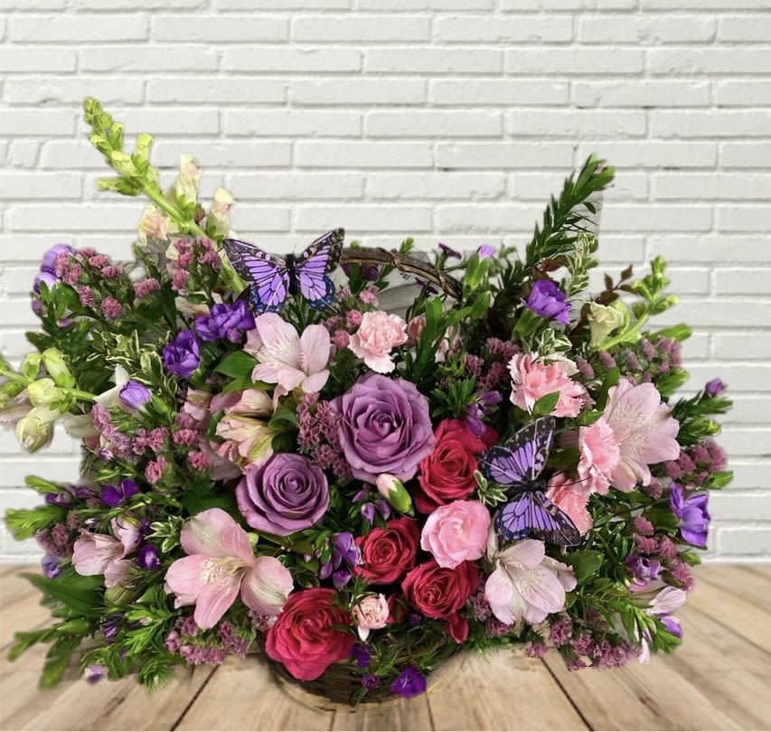 Mixed bouquet of pink and purple flowers with butterfly accents