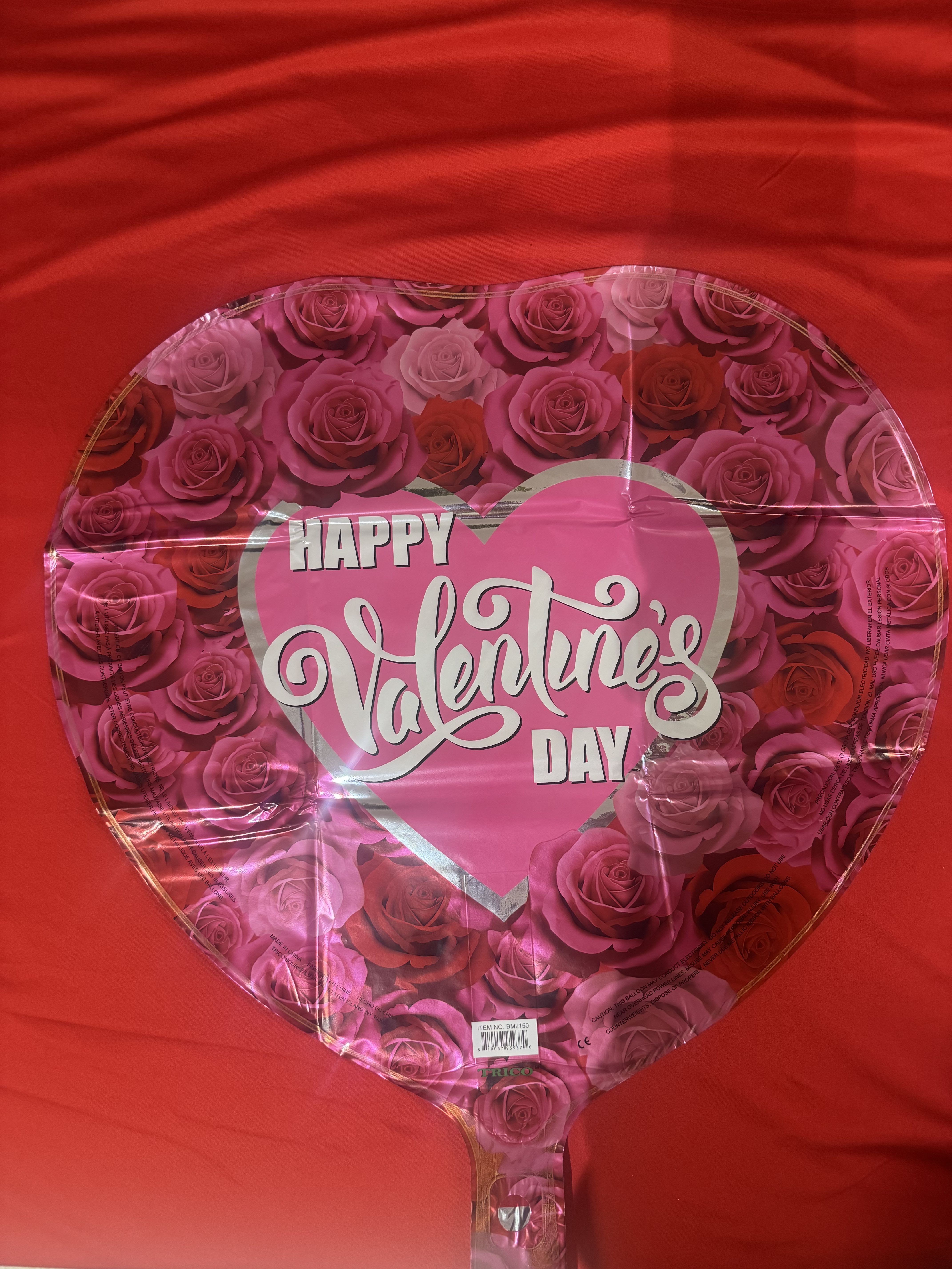 Heart-shaped Valentine’s Day balloon with pink roses and red background