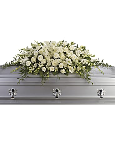 White floral casket spray on a silver casket