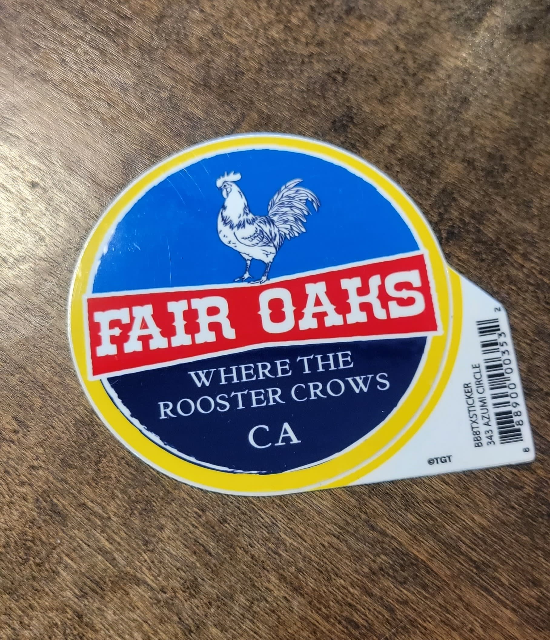 Fair Oaks sticker with a rooster logo on a wood surface