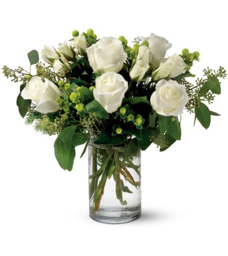 White roses arranged in a clear glass vase