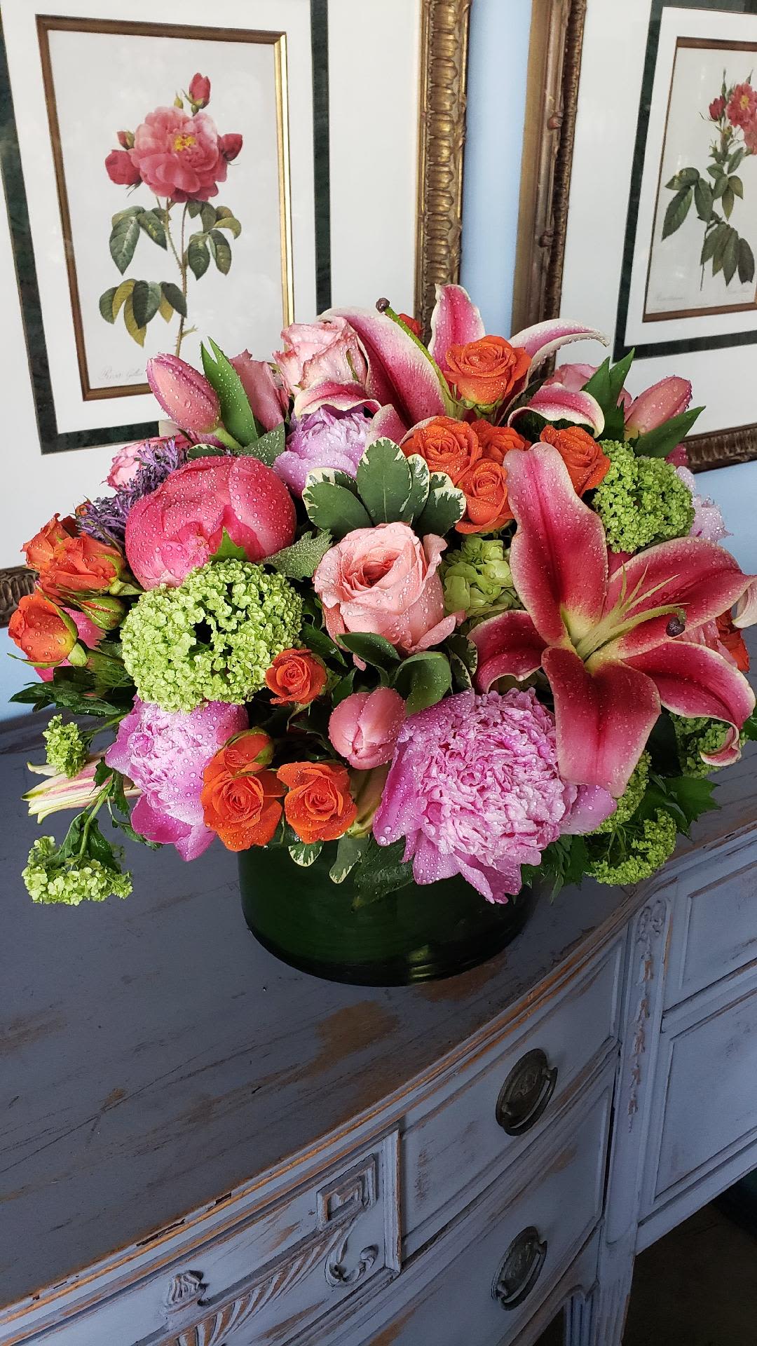 Vivid Euphoria  - An elegant, premium arrangement overflowing with the brightest summer blooms—coral peonies, oriental lilies, pink garden roses, viburnum, green hydrangeas, tulips, and spray roses. This lush mix of vivid color and texture brings warmth and joy to any space, creating a showstopping centerpiece for celebrations, milestones, or a luxurious just-because.  Please note: As a premium design, flower varieties may adjust slightly with seasonal availability; we’ll always maintain the same vibrant look, fullness, and top-tier quality.  Freshness Guarantee: We stand behind our quality. Your flowers are guaranteed to look fresh and beautiful for 3–5 days from delivery.  To help them last:  •Top off the vase with clean water daily.  •Keep arrangements away from direct sun, heat, and drafts.  •Trim stems slightly after a couple of days if possible.