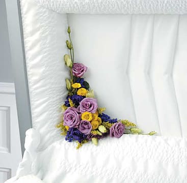 Purple roses and yellow flowers arranged on a white bedspread