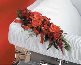 Red floral arrangement on a white casket