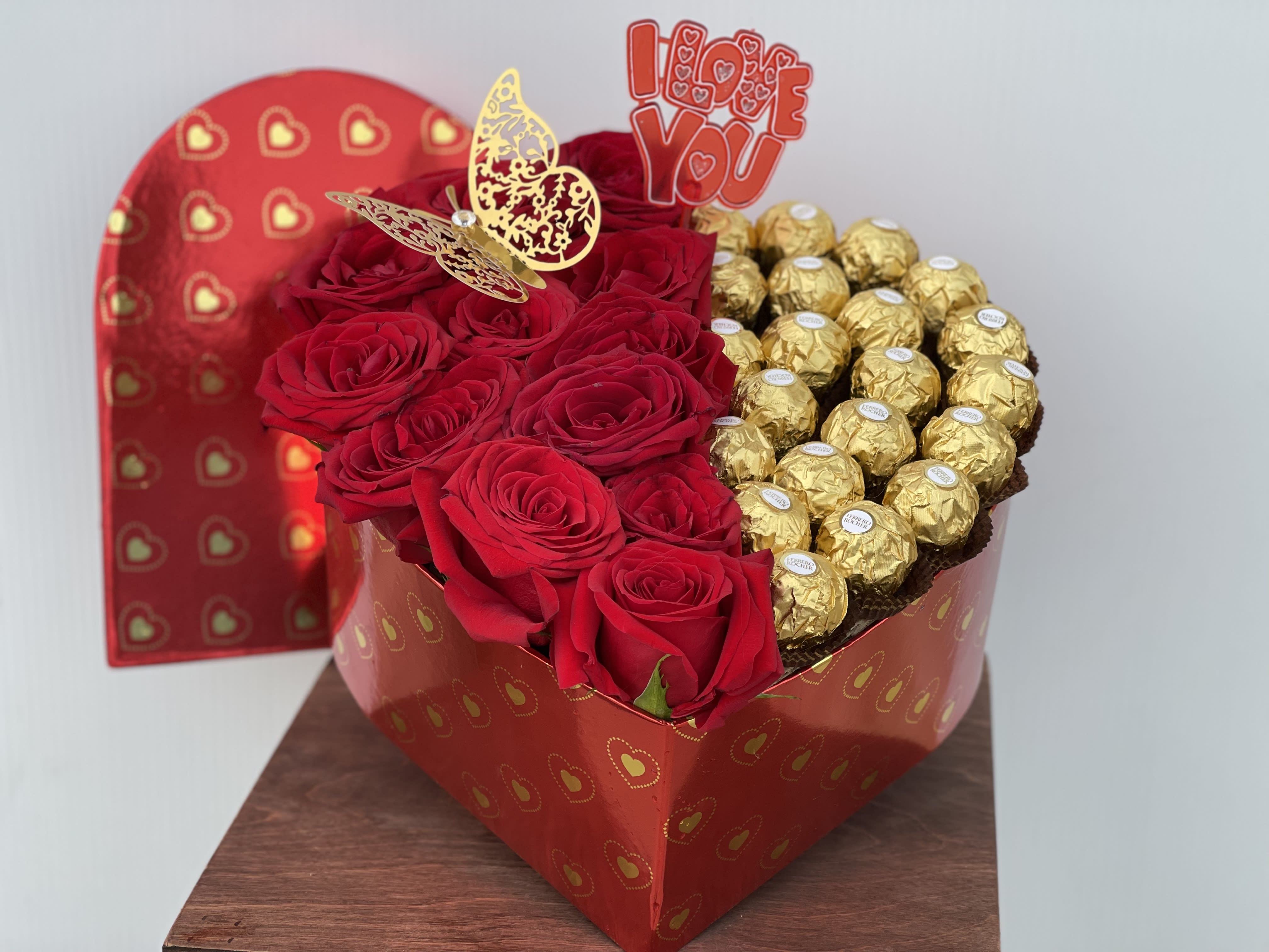 Heart-shaped box with red roses and gold-wrapped chocolates