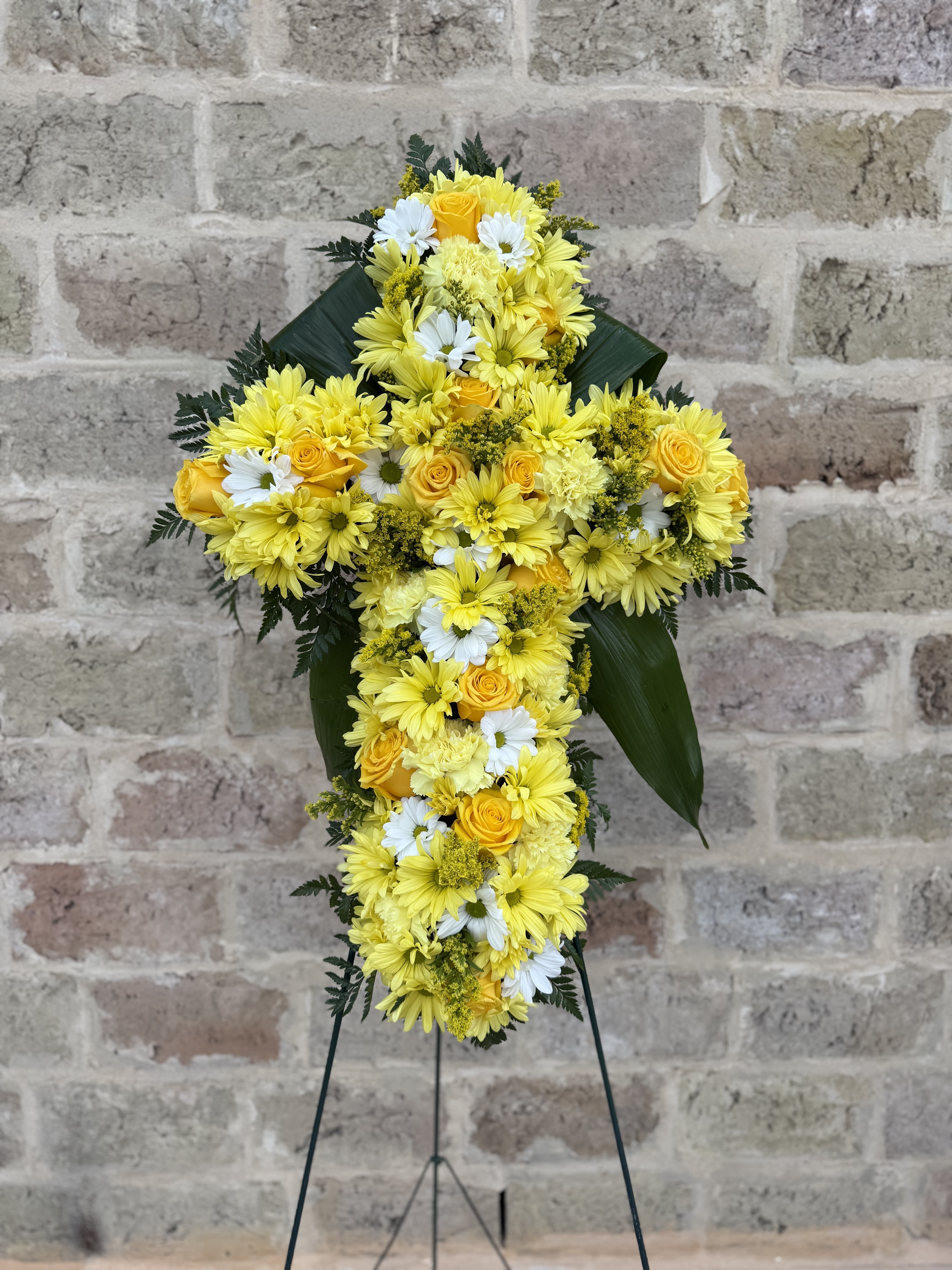 Yellow and white floral cross on a stand
