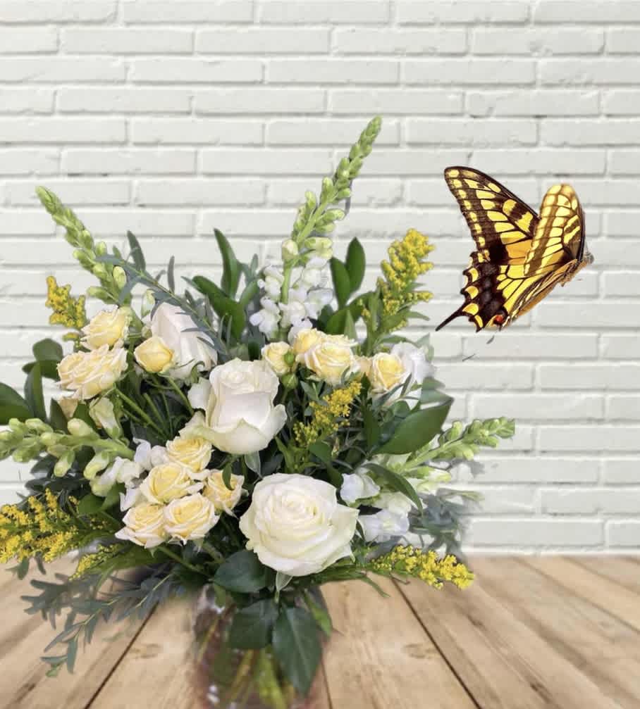 White and pale yellow flower arrangement with a butterfly decoration