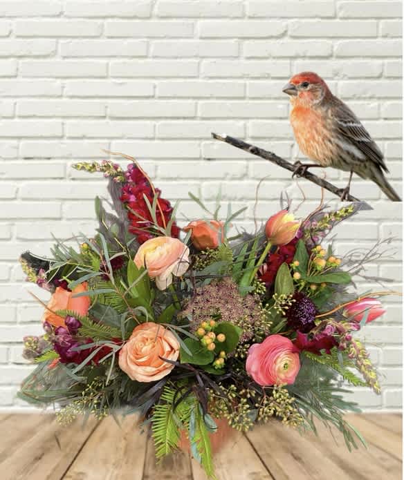 Mixed bouquet with peach and pink flowers and a bird figurine on a branch