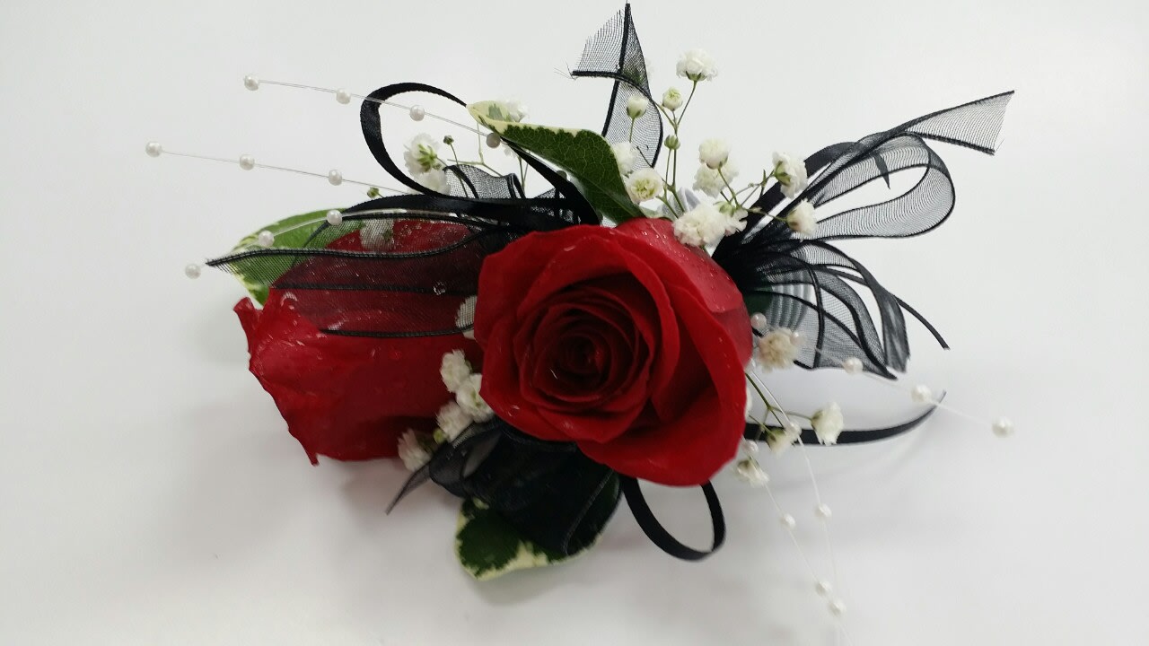 Red rose corsage with black ribbon and white baby's breath